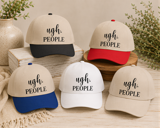 a collection of five baseball caps with the text "ugh. PEOPLE" printed on them. The caps are arranged on a wooden surface, with some placed on top of a stack of books and others on a wooden stand. There are also some decorative elements in the background, such as a vase and a plant.