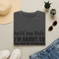 a gray t-shirt with the text "hold my halo, I'm about to do others" printed on it, along with a pair of jeans, sunglasses, a straw hat, and a pair of white sneakers.