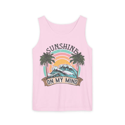 A pink tank top with a graphic design featuring a sunset, palm trees, and the text "SUNSHINE ON MY MIND".