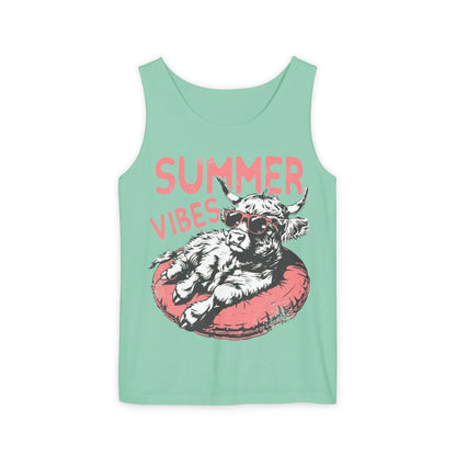 A green tank top with a graphic design of a cow wearing sunglasses and resting on a red inner tube, with the text "SUMMER VIBES" written above the image.