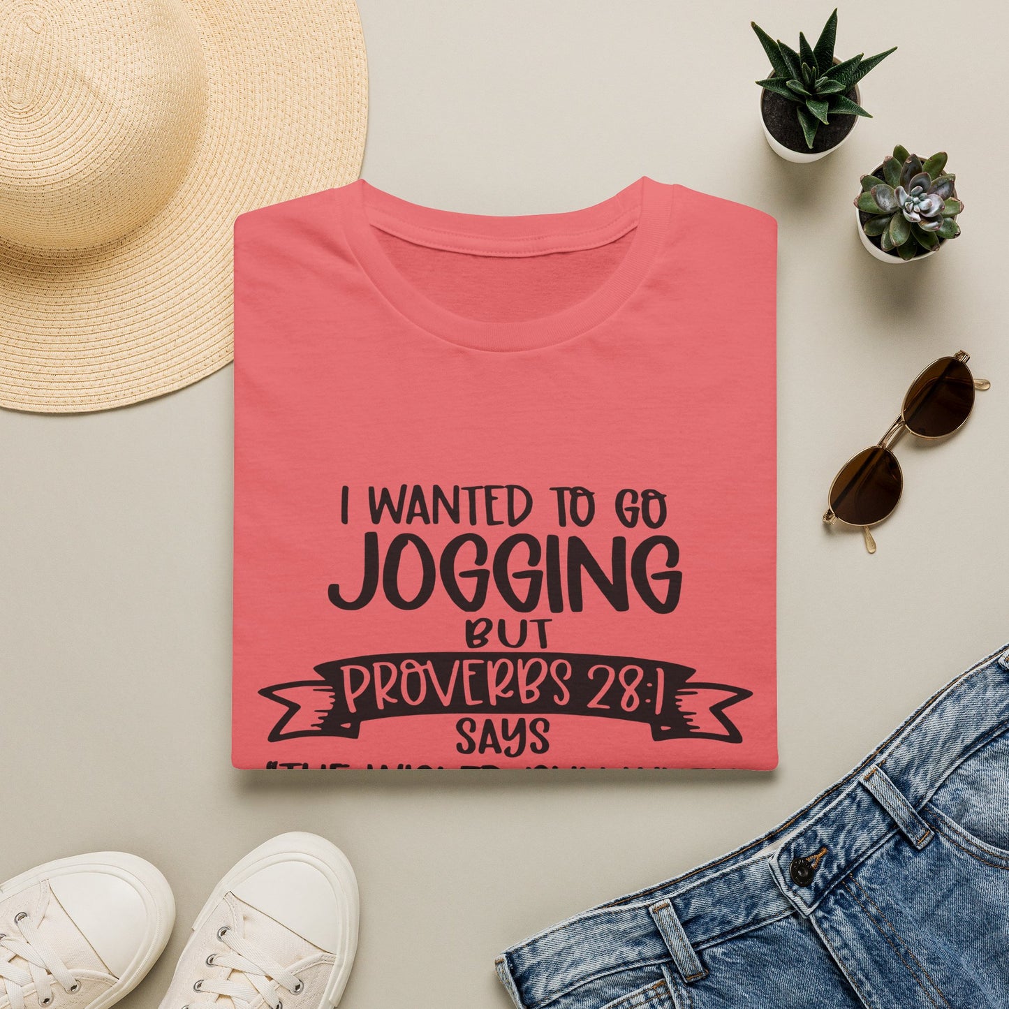 a pink t-shirt with a humorous text, a pair of jeans, sunglasses, a hat, and some potted plants arranged on a light-colored surface.