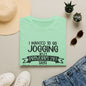 a green t-shirt with a humorous text, a pair of sunglasses, a hat, a pair of sneakers, and some potted plants.