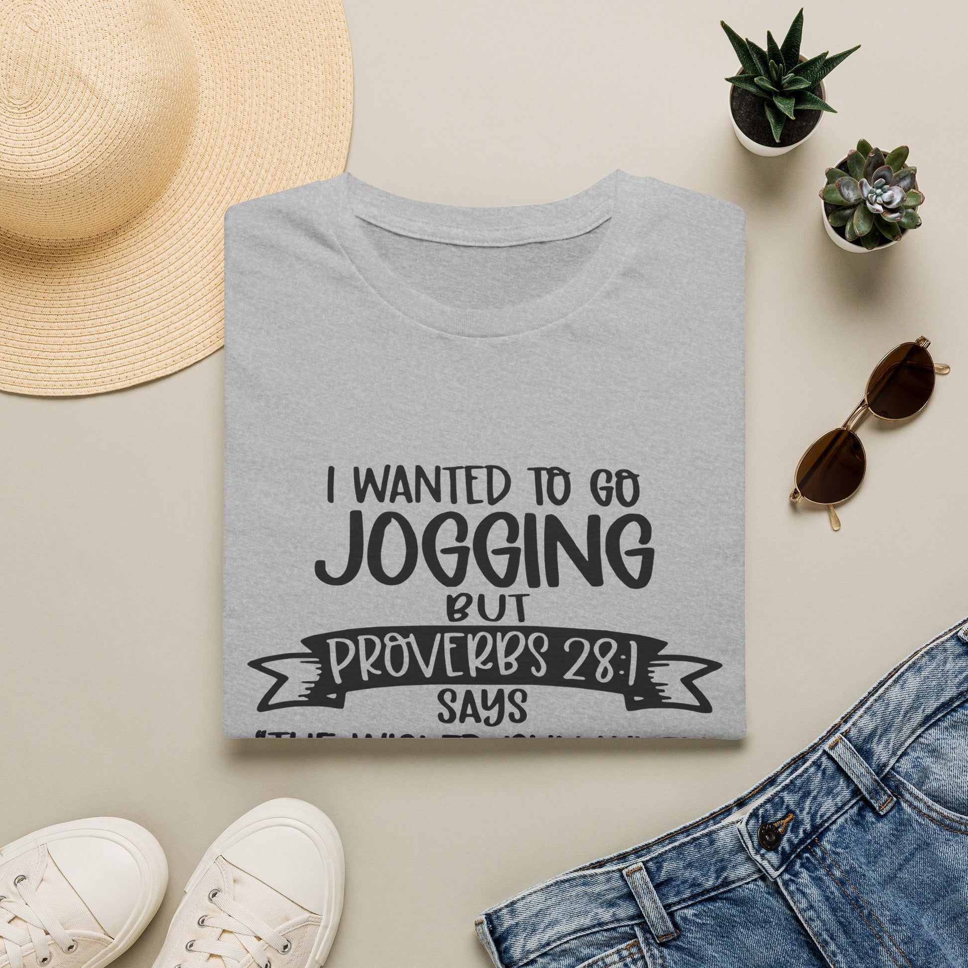 a gray t-shirt with a humorous text, a pair of jeans, sunglasses, a hat, and some potted plants arranged on a flat surface.