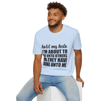 A man wearing a white t-shirt with text on it is sitting on a white stool.